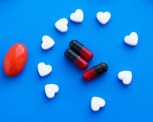 Medical tablets and capsules isolated on a blue background.