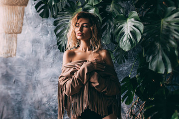 Obraz premium Portrait of a young girl in black lingerie and a brown cape.