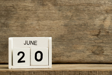 White block calendar present date 20 and month June on wood background