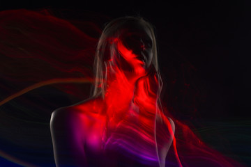 Conceptual avant-garde silhouette portrait of a beautiful blonde girl covered with multicolored...