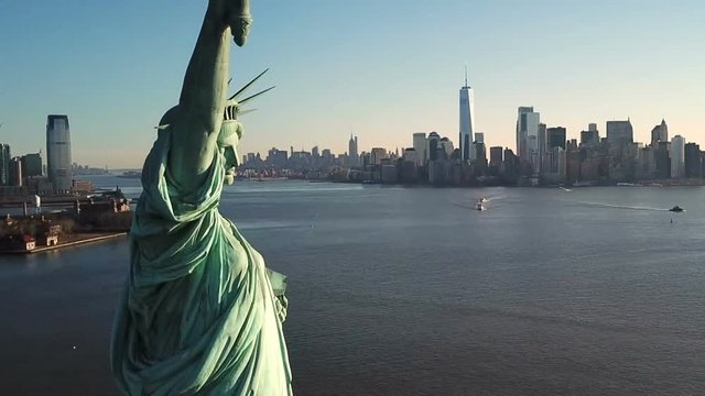 Statue of Liberty aerial pulling back from close up with Manhattan skyline in background in New York City NYC in 1080 HD
