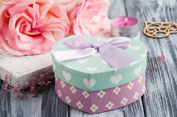 Pink gift box, roses, lit candle