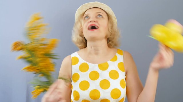 Funny woman with mimosa flowers bunch in hat smilling 
