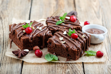 Chocolate brownie cake, dessert with nuts on wooden background.