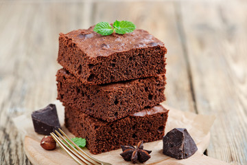 Chocolate brownie cake, dessert with nuts on wooden background.