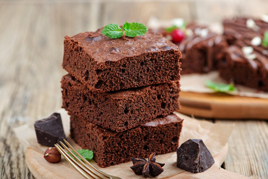 Chocolate brownie cake, dessert with nuts on wooden background.