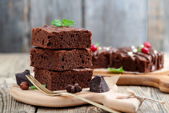 Chocolate brownie cake, dessert with nuts on wooden background.
