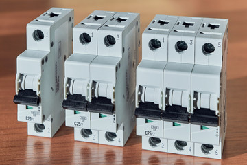 Three modular electrical circuit breakers on the table. The switch is single-pole, double-pole and...