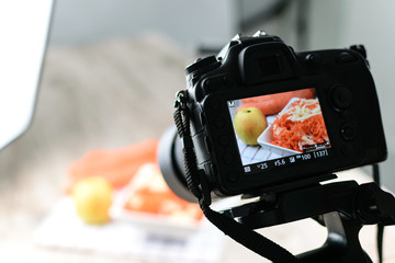Concept image  -  rear view of DSLR camera making a food photography in the photo studio