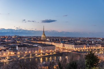 Fototapeta na wymiar Turin skyline at dusk, panorama cityscape at Torino, Italy, with the Mole Antonelliana over the city. Scenic colorful light and dramatic sky.