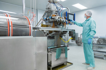 Pharmacy industry factory man worker in protective clothing in sterile working conditions