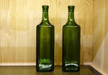 Two bottles stand on the table on the background of a wooden wall.