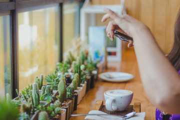 Beautiful woman taking a coffee picture in a cafe alone.