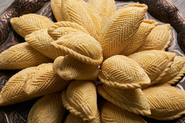 Azerbaijan national pastry Shekerbura with nuts and honey for Novruz holiday on wooden table background