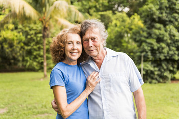 Portrait of a beautiful elderly couple standing embracing outdoors