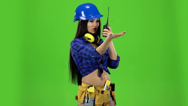 Girl in a helmet with a walkie-talkie on a green background