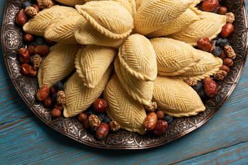 National Azerbaijan sweet pastry shekerbura with nuts and honey on wooden table background, close...