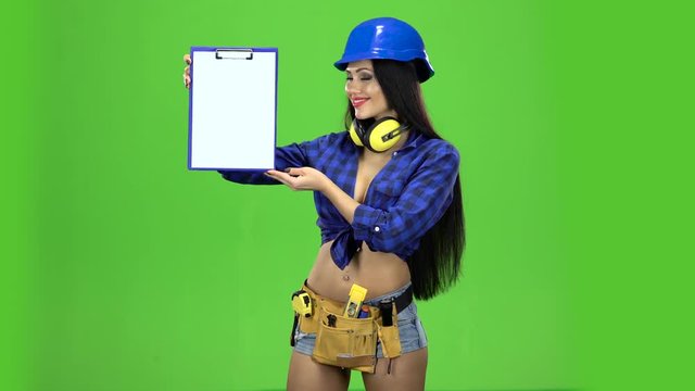 Girl with cute smile shows a folder tablet on green background