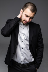 Handsome young business man in modern elegant suit isolated over white background. Concept of idea, ask question, think up, choose, decide,