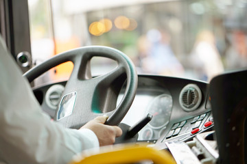 Hands of driver in a modern bus by driving.Concept - close-up of bus driver steering wheel and driving passenger bus - obrazy, fototapety, plakaty
