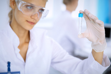 Fototapeta premium Female scientific researcher in laboratory studying substances or blood sample. Medicine and science concept