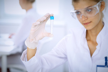 Female scientific researcher in laboratory studying substances or blood sample. Medicine and science concept