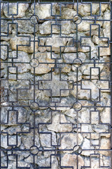 Vintage wrought iron grille and stone ancient wall as background or backdrop