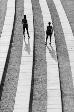 Rear view of two athlete women on concrete steps