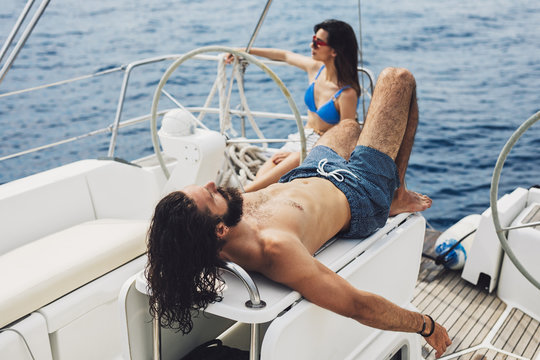 Man and Woman Sunbathing on Sailing Boat