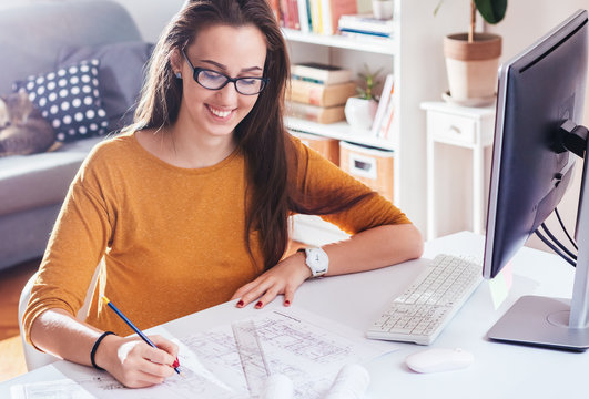 Beautiful female designer or architect  drawing and working on a computer at home office, remote
