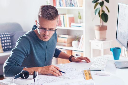 Male designer or architect  working on a computer at modern home office
