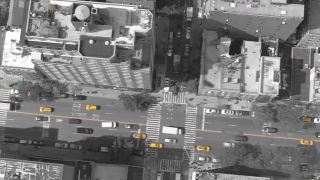 AERIAL TOP DOWN, ISOLATED YELLOW: Striking yellow cabs stand out in cinematic gray cityscape. Flying shot of bustling city traffic driving past people walking along concrete sidewalk in New York City