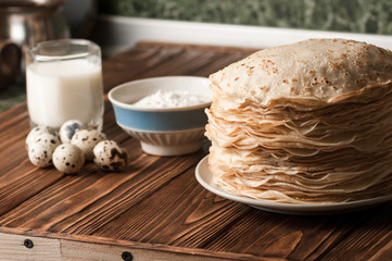 Ingredients for preparation of pancakes, on wooden background.