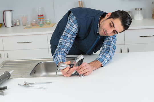 plumber fixing tap on sink