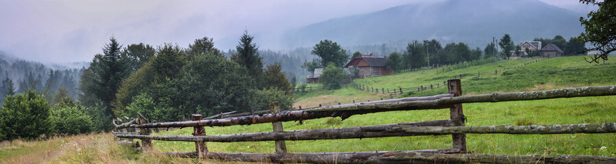 Fototapeta na wymiar Rural landscape, panorama, banner, with a wooden fence for cattle, the Ukrainian Carpathians.