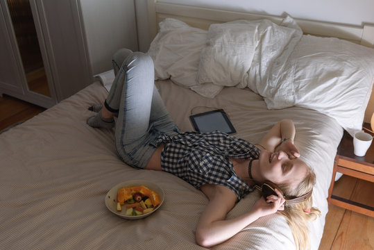 Woman listening to music on bed