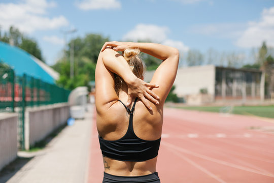 Woman exercising outdoor, from the back