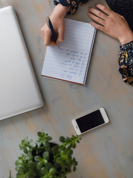 Crop woman writing plan