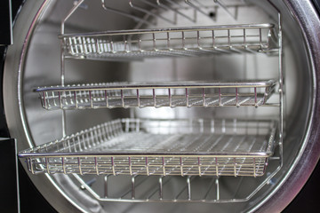 Sterilizing medical instruments in autoclave, Tongs for manicure on the background of a medical autoclave