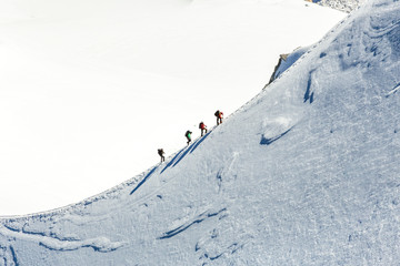 Mont Blanc mountaneers walking on snowy ridge.