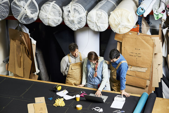 Colleagues Discussing In Warehouse At Sofa Workshop