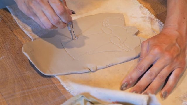 Female hands working with clay angel