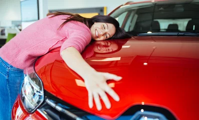 Foto op Canvas Happy beautiful young woman buying a new car at the car showroom. © hedgehog94