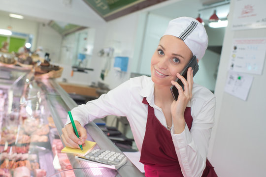 Woman in butchers taking phone order