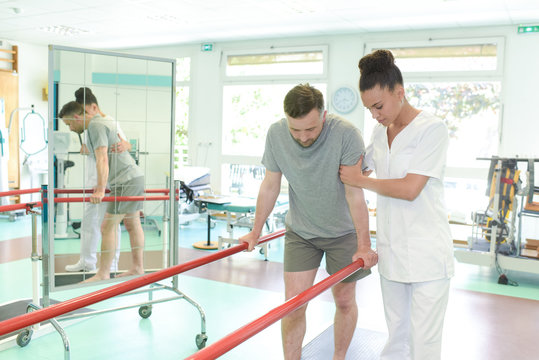 female physiotherapist teaching patient how to walk