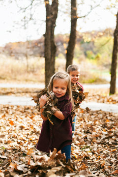 Autumn: Little Girl Carrying Handfuls Of Leaves