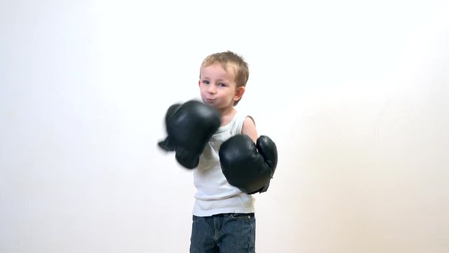 Little funny child with boxing gloves playing the winner