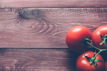 Freshly picked ripe tomatoes on a wooden retro table. Preparations for cooking. Close up. Modern faded mood style