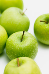 Close up shot of organic green yellow Granny Smith or Golden Delicious apples with little blemishes on white background