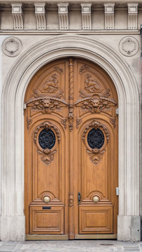Antique wooden door with carved stone structure in an ancient palace in Paris.